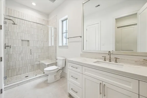 a bathroom with a double vanity sink toilet and shower