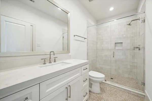 a bathroom with a sink a toilet and shower