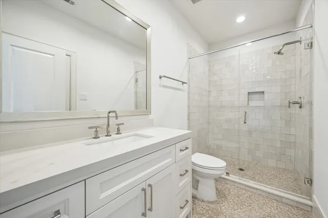 a bathroom with a sink a toilet and shower