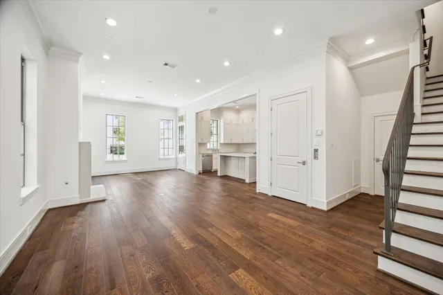 a view of empty room with wooden floor and window
