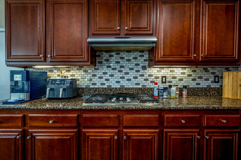 18668 Alderbrook Drive Riverside, CA 92508 - Photo 11 of 28 a kitchen with granite countertop wooden cabinets and a sink