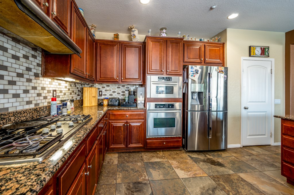 18668 Alderbrook Drive Riverside, CA 92508 - Photo 13 of 28 a view of a kitchen with stainless steel appliances a stove a refrigerator and cabinets