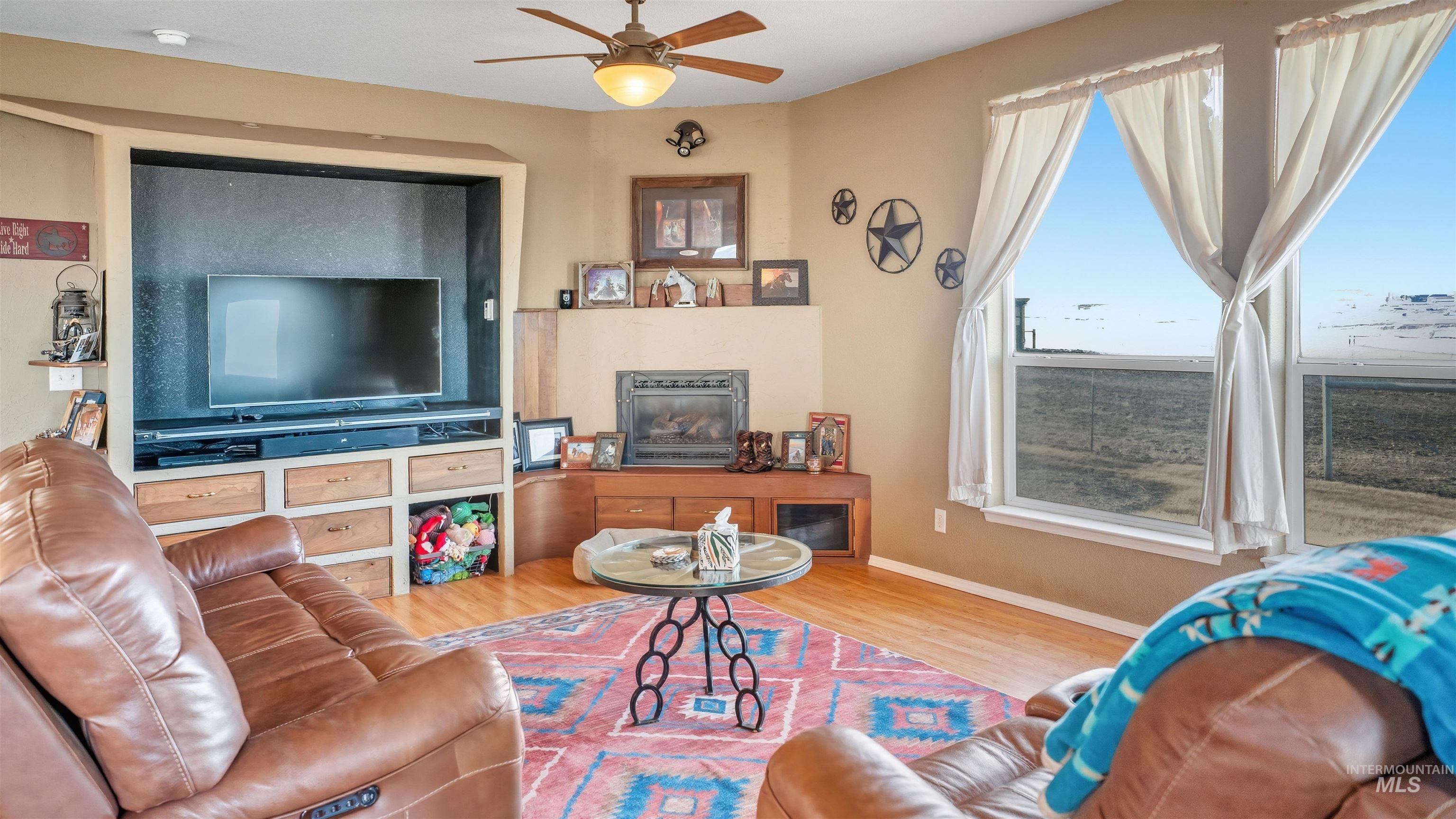 19397 Cloverland Road Asotin, WA 99402 - Photo 12 of 37 Living area with ceiling fan, wood finished floors, and a glass covered fireplace