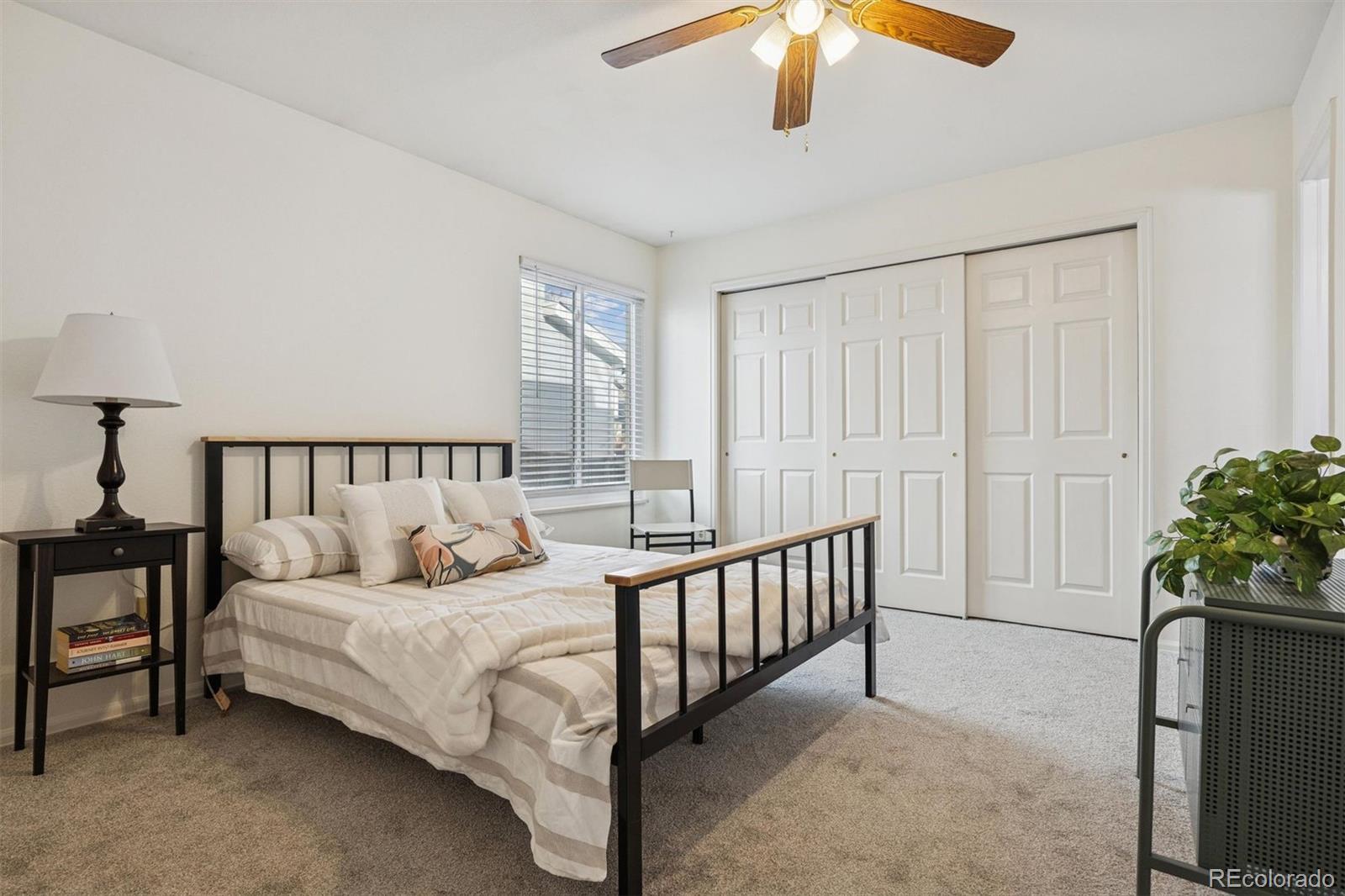 9471 Burlington Lane Highlands Ranch, CO 80130 - Photo 21 of 50 a bedroom with a bed and a chandelier