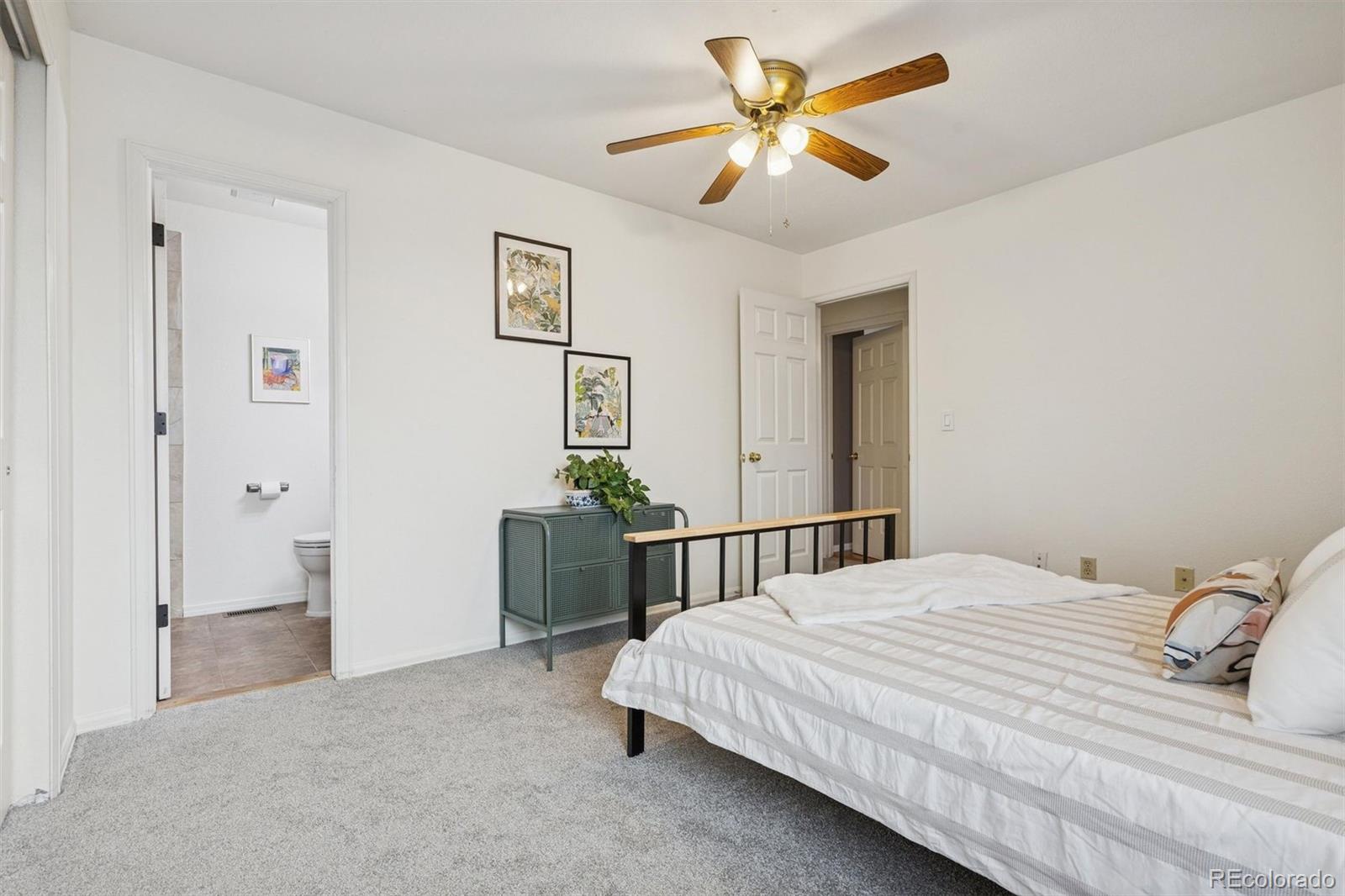 9471 Burlington Lane Highlands Ranch, CO 80130 - Photo 22 of 50 a bedroom with a large bed and a chandelier