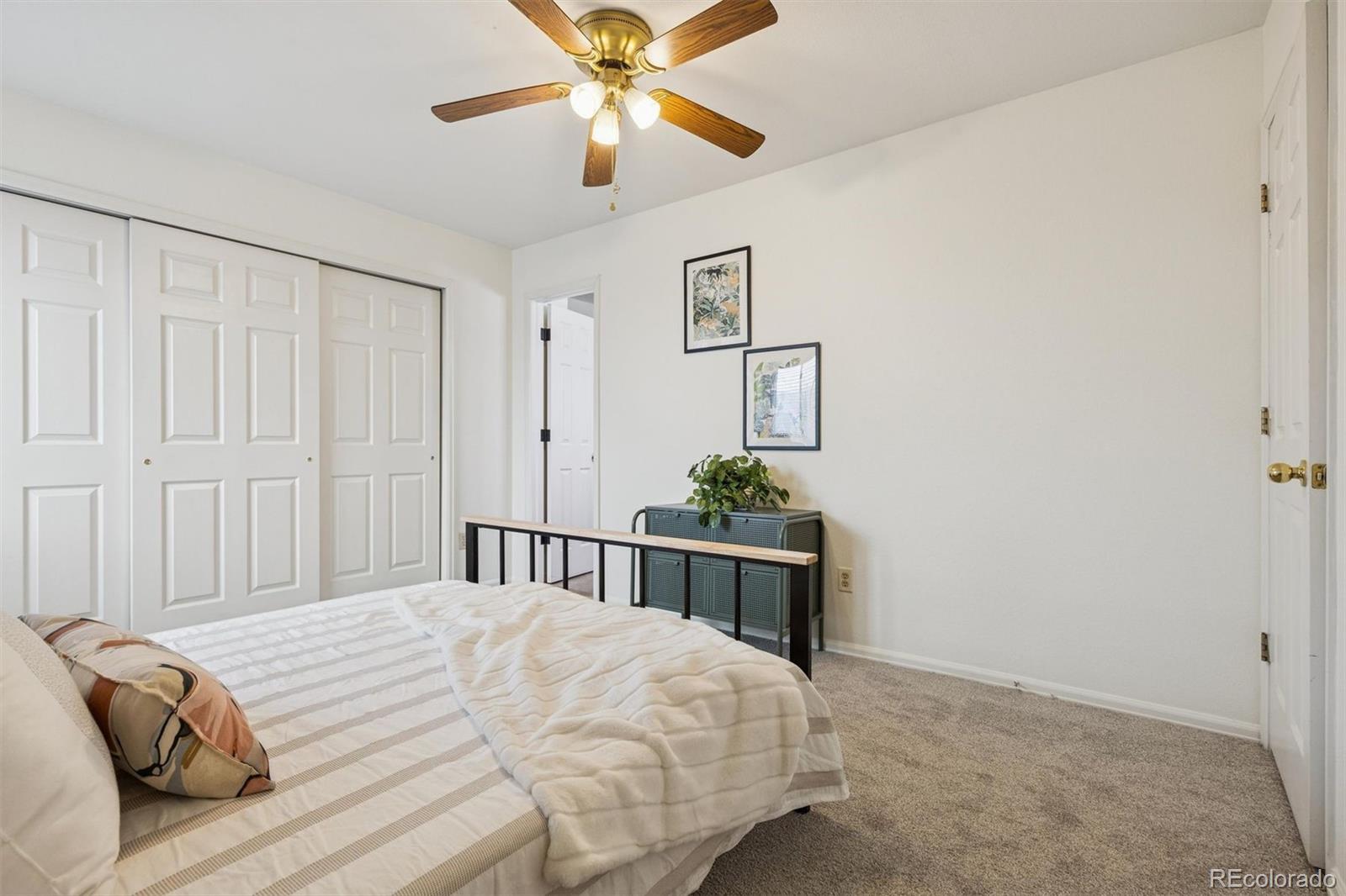 9471 Burlington Lane Highlands Ranch, CO 80130 - Photo 23 of 50 a bedroom with a bed and a chandelier