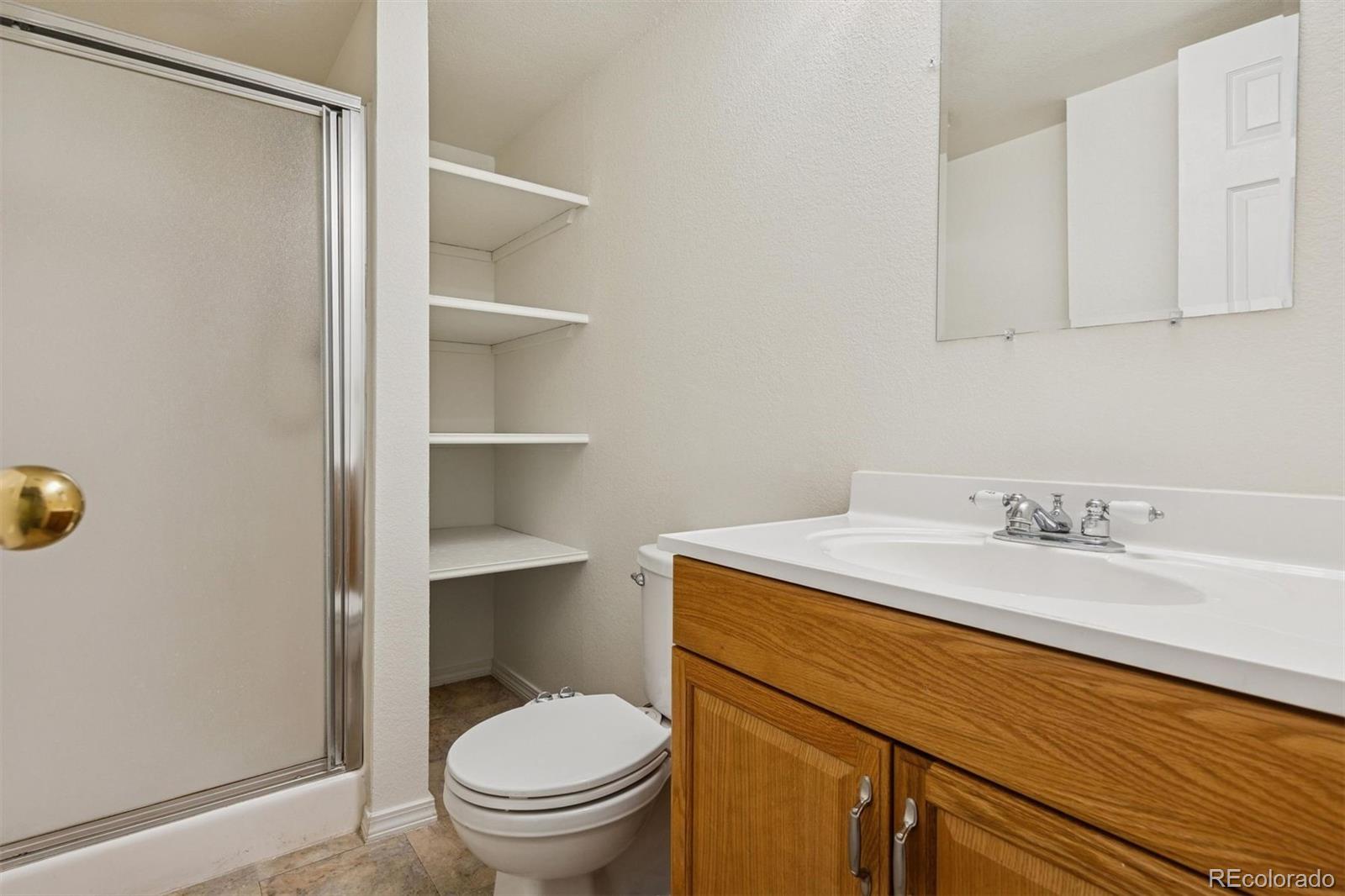 9471 Burlington Lane Highlands Ranch, CO 80130 - Photo 36 of 50 a bathroom with a granite countertop sink toilet and a mirror