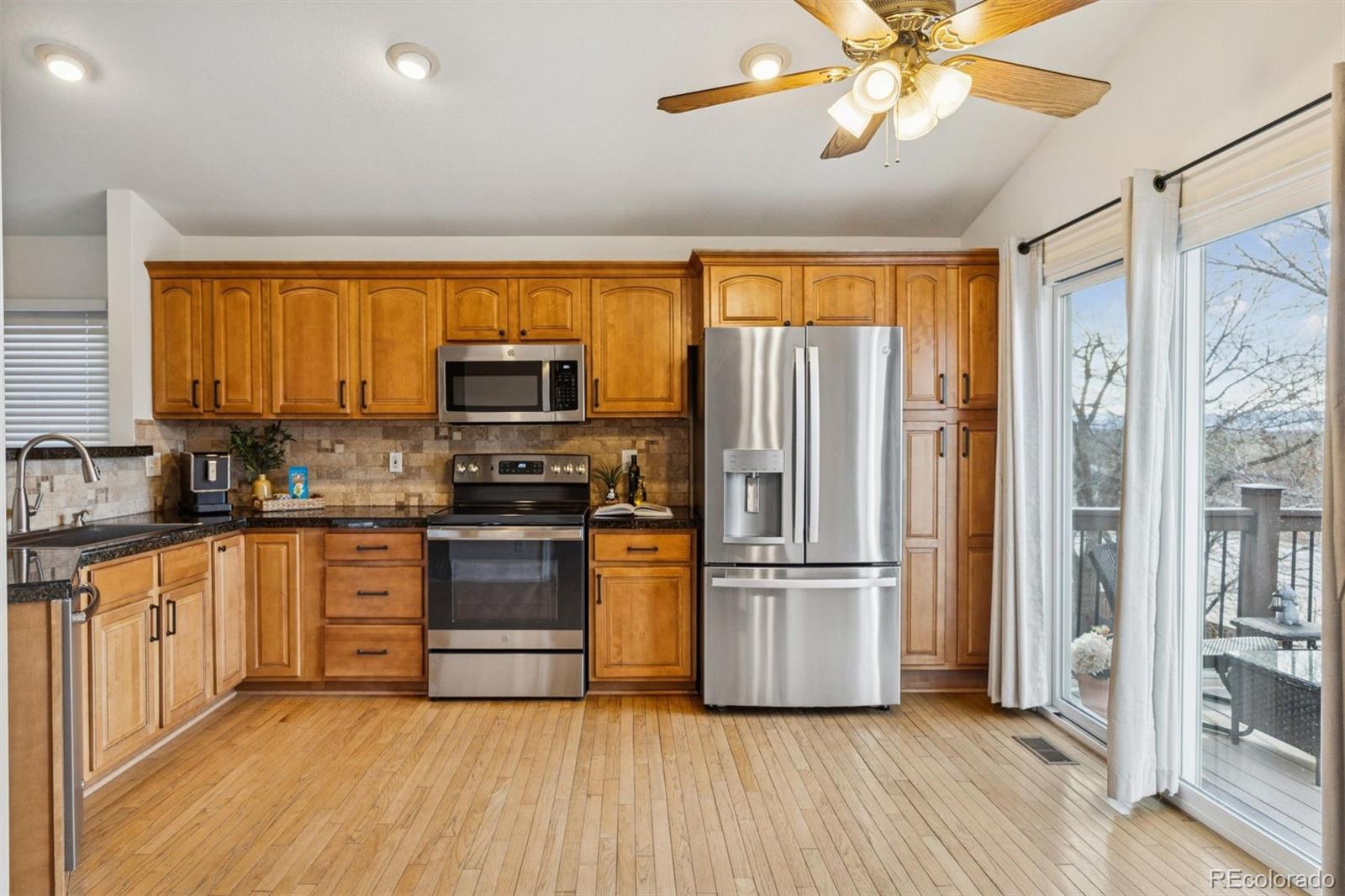 9471 Burlington Lane Highlands Ranch, CO 80130 - Photo 7 of 50 a kitchen with stainless steel appliances granite countertop a refrigerator microwave and stove top oven