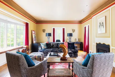 a living room with furniture fireplace and large windows