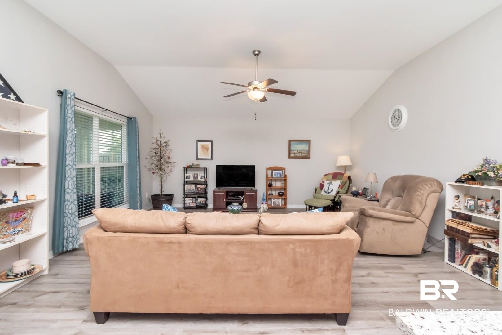 1295 Hayward Loop Foley, AL 36535 - Photo 3 of 29 Spacious room featuring vaulted ceilings, wood-finish flooring, a large window with blinds, and a ceiling fan with integrated lighting