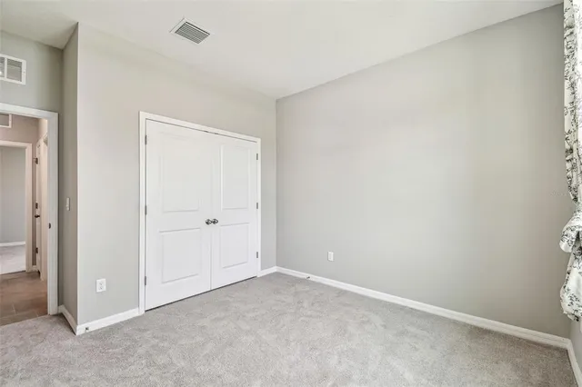 an empty room with closet and a window
