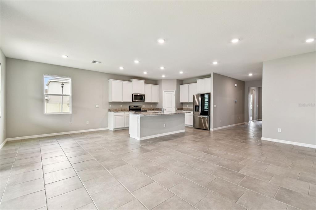 33870 Field Maple Loop Wesley Chapel, FL 33545 - Photo 18 of 38 a view of kitchen with stainless steel appliances kitchen island granite countertop a refrigerator and a stove top oven