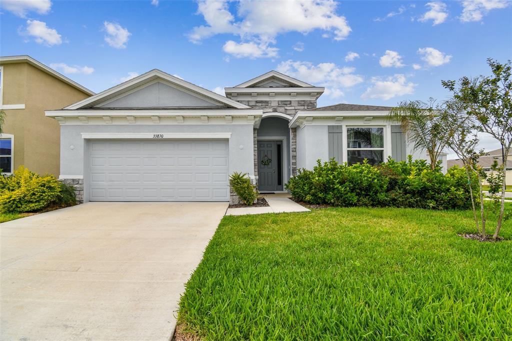 33870 Field Maple Loop Wesley Chapel, FL 33545 - Photo 27 of 38 a front view of a house with a garden and plants