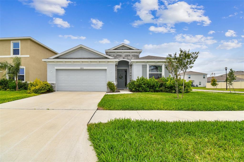 33870 Field Maple Loop Wesley Chapel, FL 33545 - Photo 30 of 38 a front view of a house with a garden