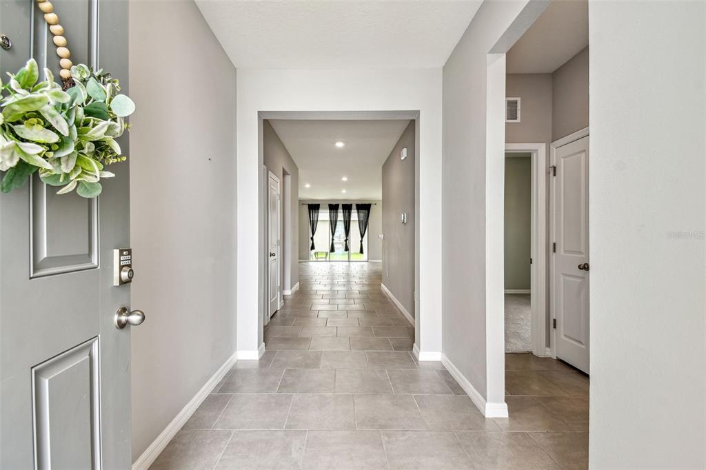 33870 Field Maple Loop Wesley Chapel, FL 33545 - Photo 4 of 38 a view of hallway with livingroom and chandelier
