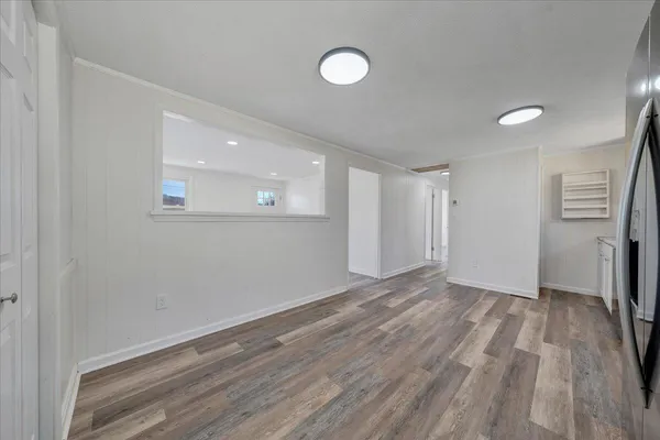 a view of an empty room with wooden floor