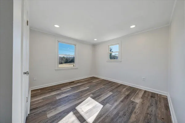 a view of empty room with wooden floor