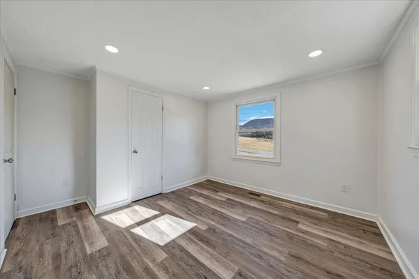 a view of empty room with wooden floor