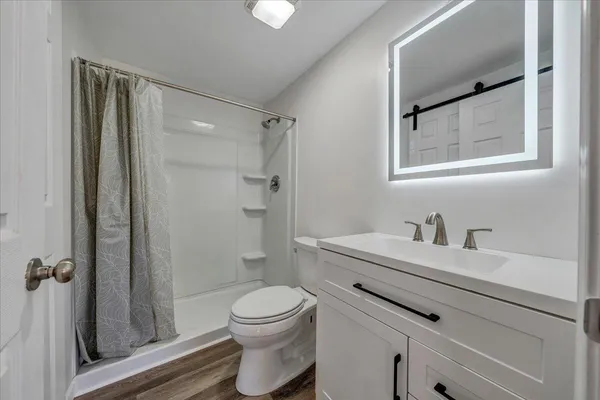 a bathroom with a toilet a sink and shower