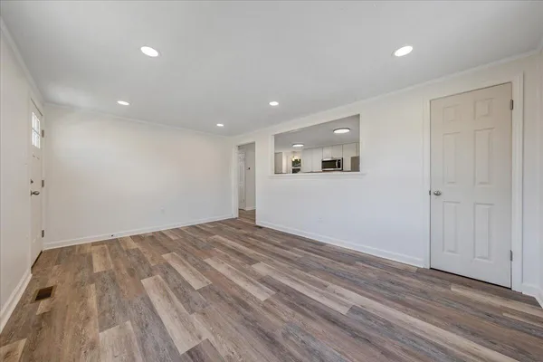 a view of empty room with wooden floor