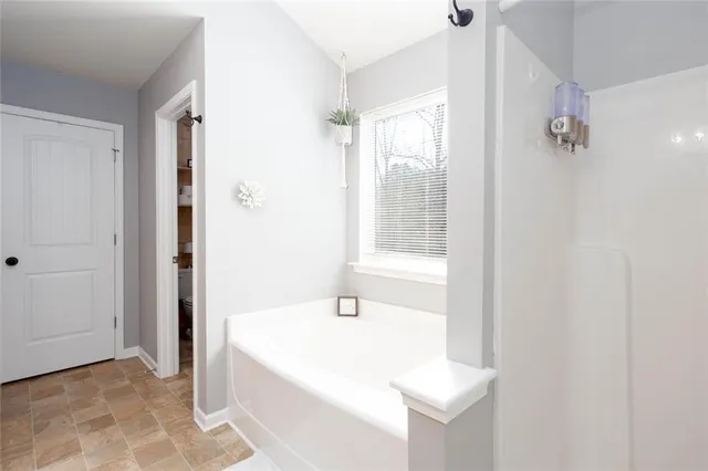 a bathroom with a tub sink and mirror