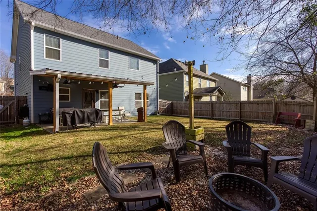 an aerial view of a house with swimming pool and large trees