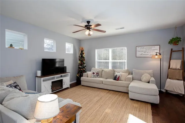 a living room with furniture a flat screen tv and a large window