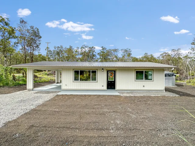 a front view of a house with a yard and potted plants