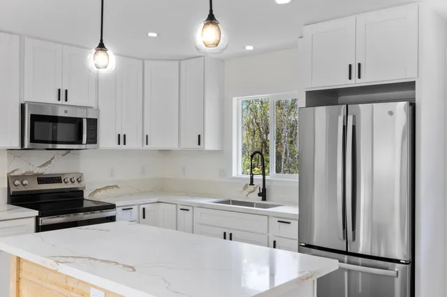 a kitchen with stainless steel appliances a refrigerator sink and microwave
