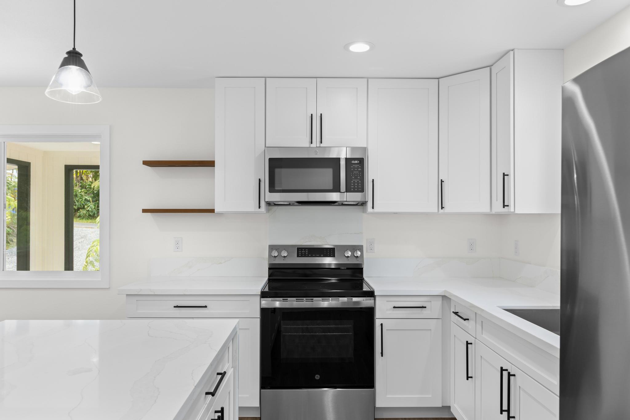 11-3116-a Mokuna Street Mountain View, HI 96771 - Photo 10 of 15 a kitchen with white cabinets and black appliances