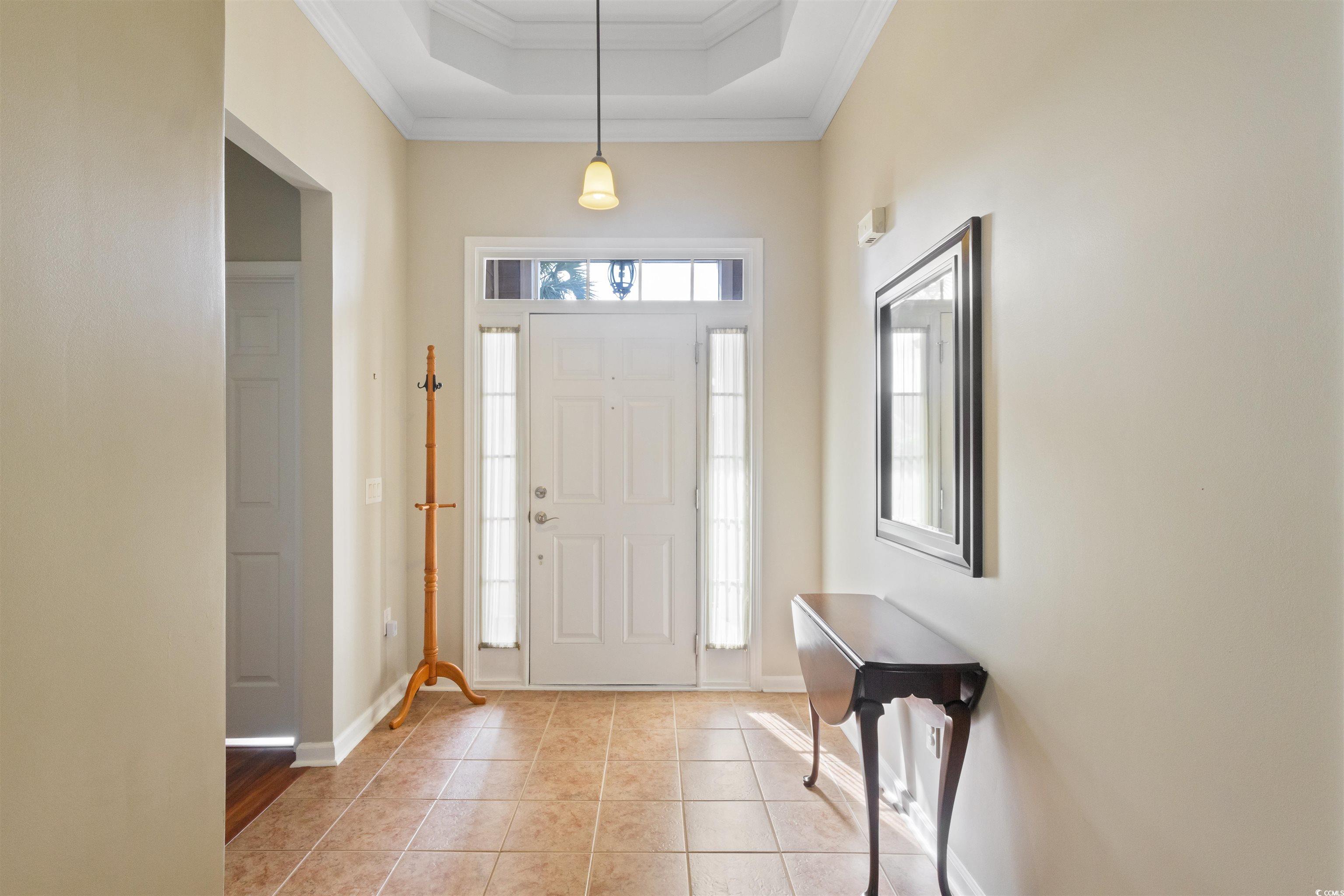 Foyer with ornamental molding, light tile patterne