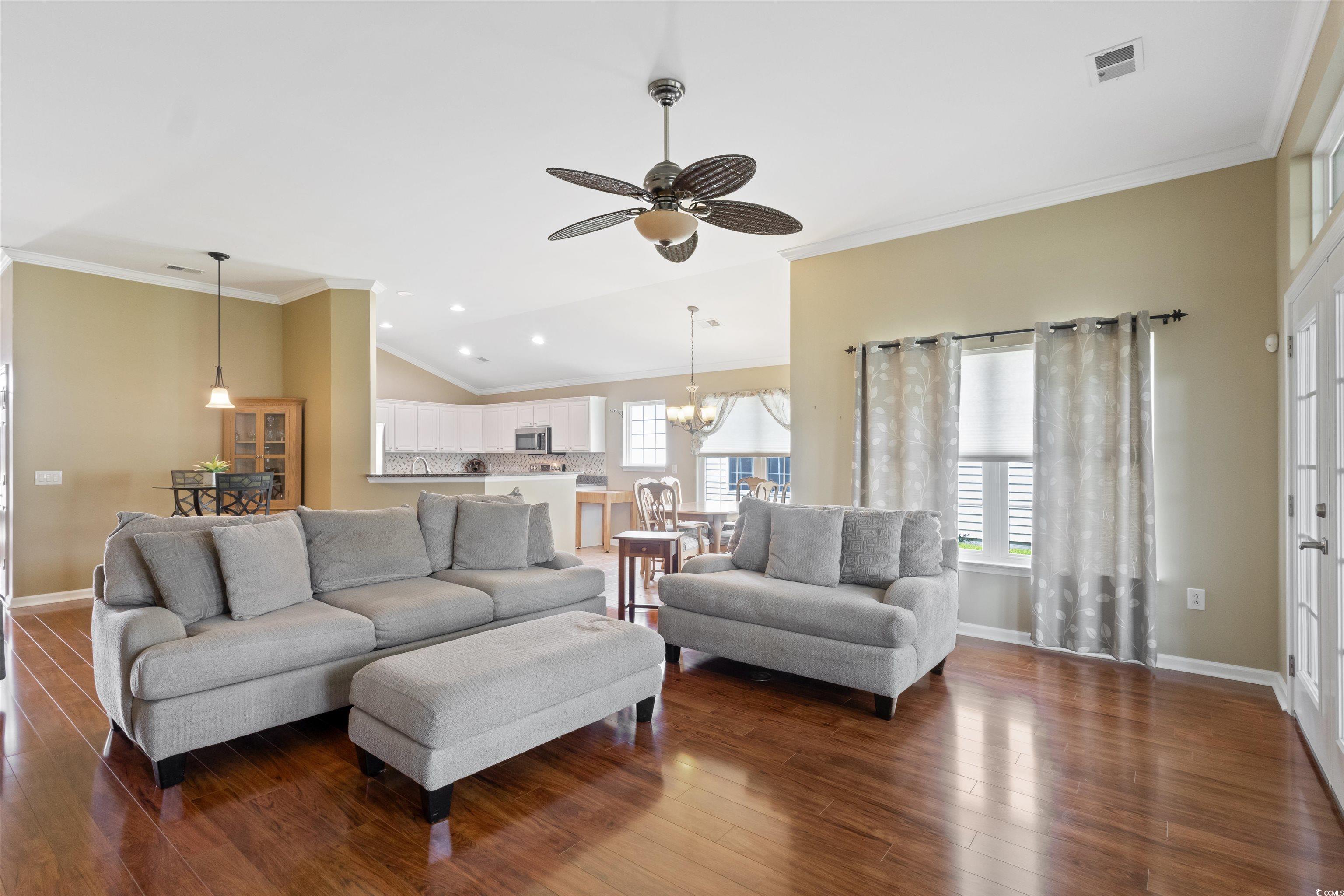 Living area with dark wood-style flooring, a chand