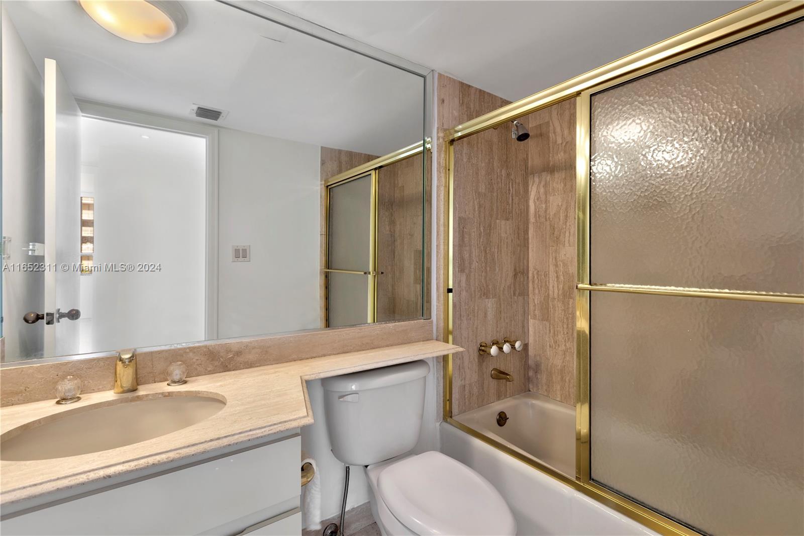 2 Grove Isle Drive, Unit B402 Miami, FL 33133 - Photo 17 of 35 a bathroom with a granite countertop sink toilet and shower