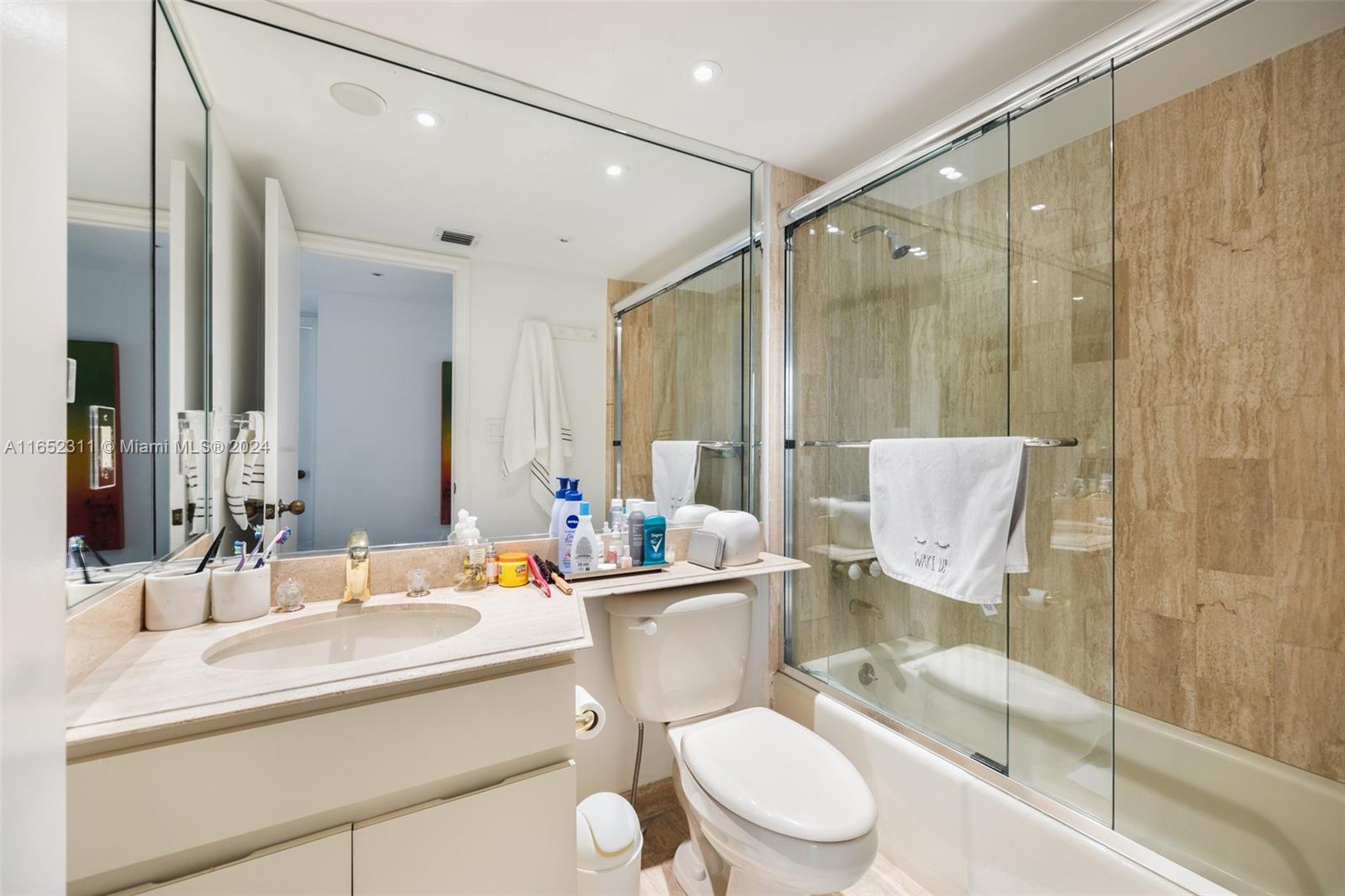 2 Grove Isle Drive, Unit B402 Miami, FL 33133 - Photo 18 of 35 a bathroom with a sink toilet a mirror and shower