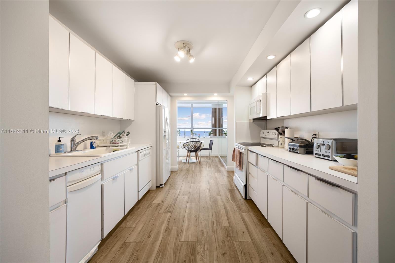 2 Grove Isle Drive, Unit B402 Miami, FL 33133 - Photo 20 of 35 a kitchen with kitchen island granite countertop lots of counter top space and cabinets