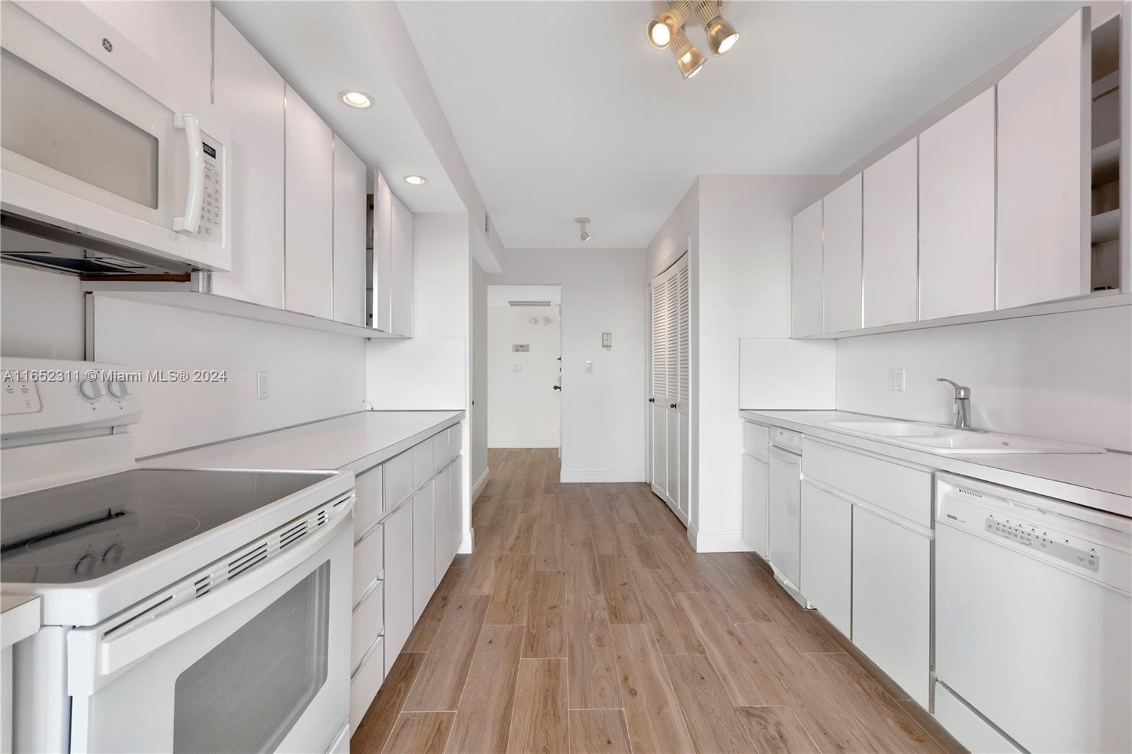 2 Grove Isle Drive, Unit B402 Miami, FL 33133 - Photo 22 of 35 a kitchen with granite countertop white cabinets and white appliances