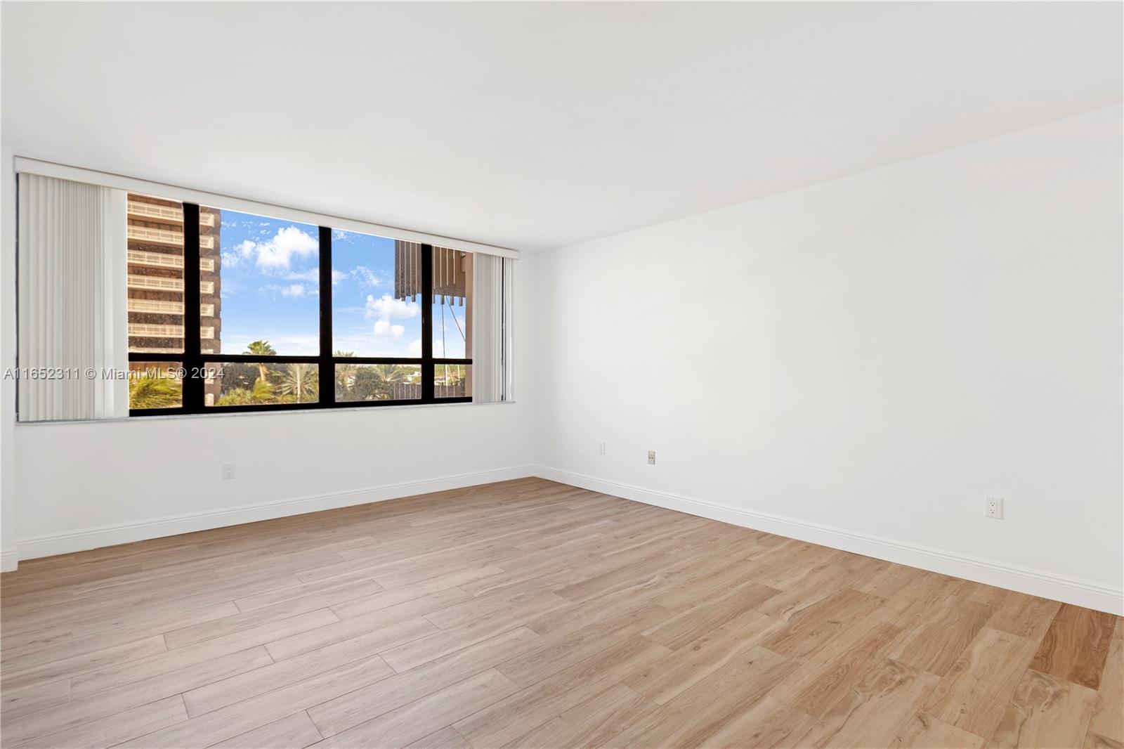 2 Grove Isle Drive, Unit B402 Miami, FL 33133 - Photo 26 of 35 an empty room with wooden floor and windows