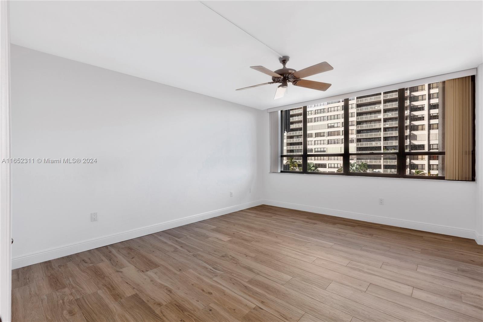 2 Grove Isle Drive, Unit B402 Miami, FL 33133 - Photo 27 of 35 a view of an empty room with window and wooden floor