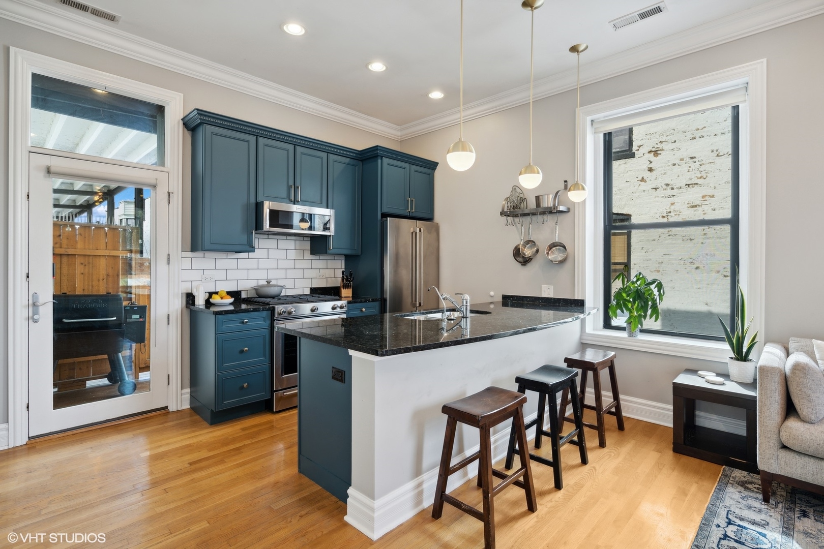 207 West St Paul Avenue, Unit 3W Chicago, IL 60614 - Photo 2 of 15 a kitchen with stainless steel appliances kitchen island granite countertop a refrigerator a stove top oven a sink dishwasher and a dining table with wooden floor