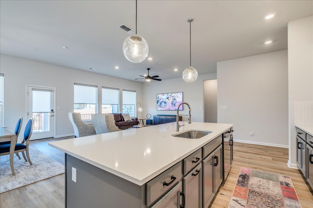 200 Christi Court Kyle, TX 78640 - Photo 40 of 40 Kitchen featuring hanging light fixtures, open floor plan, ceiling fan, a center island with sink, and recessed lighting