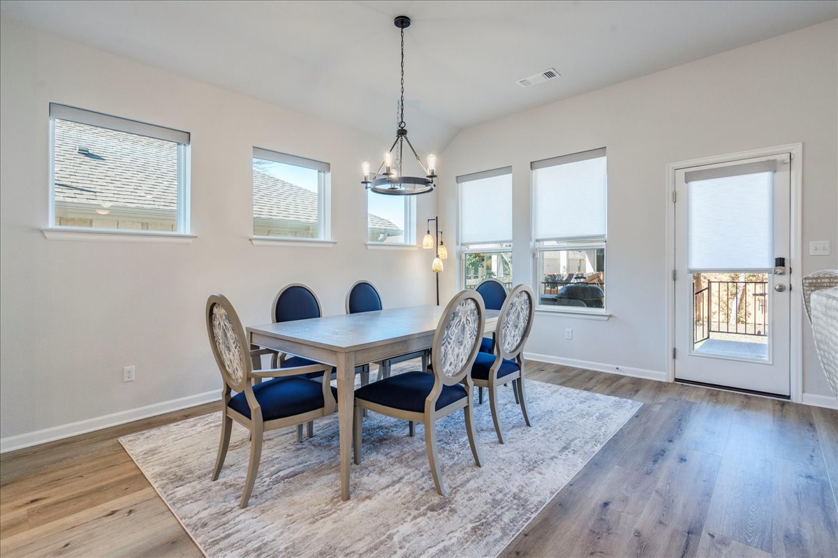 200 Christi Court Kyle, TX 78640 - Photo 14 of 40 Dining room with a chandelier, light wood-style flooring, and lofted ceiling