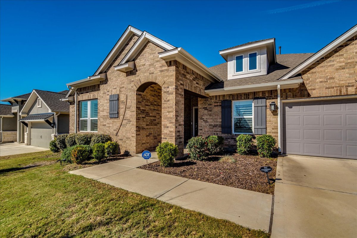 200 Christi Court Kyle, TX 78640 - Photo 2 of 40 View of front of house with a garage, concrete driveway, brick siding, a shingled roof, and a front yard