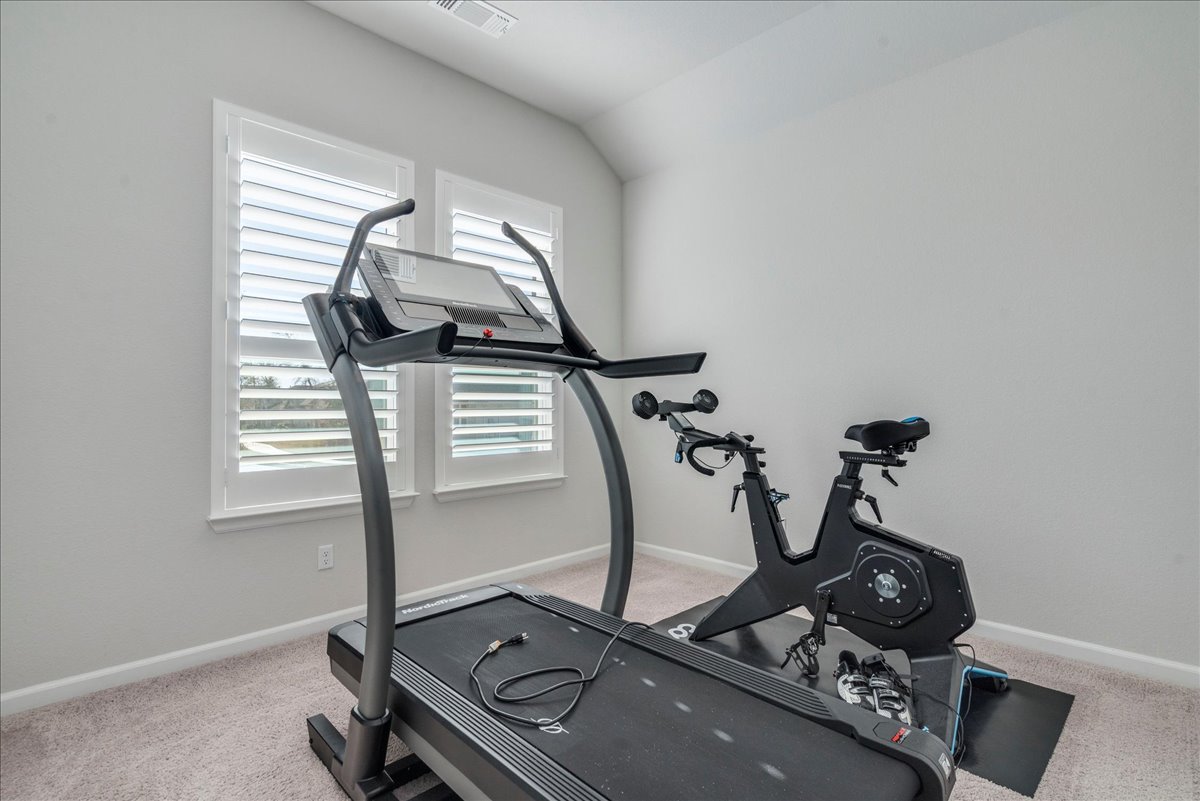 200 Christi Court Kyle, TX 78640 - Photo 24 of 40 Exercise area featuring light colored carpet and lofted ceiling