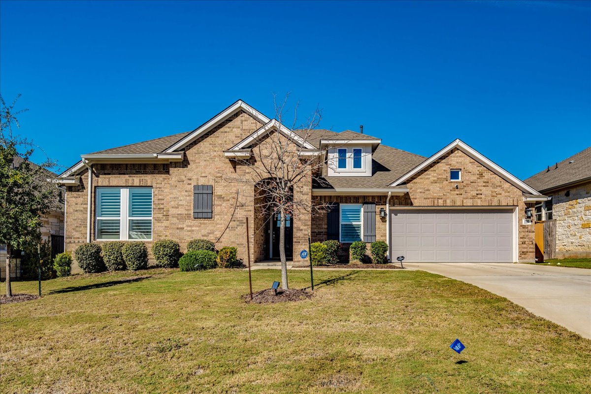 200 Christi Court Kyle, TX 78640 - Photo 3 of 40 View of front facade with driveway, a front lawn, a shingled roof, brick siding, and a garage