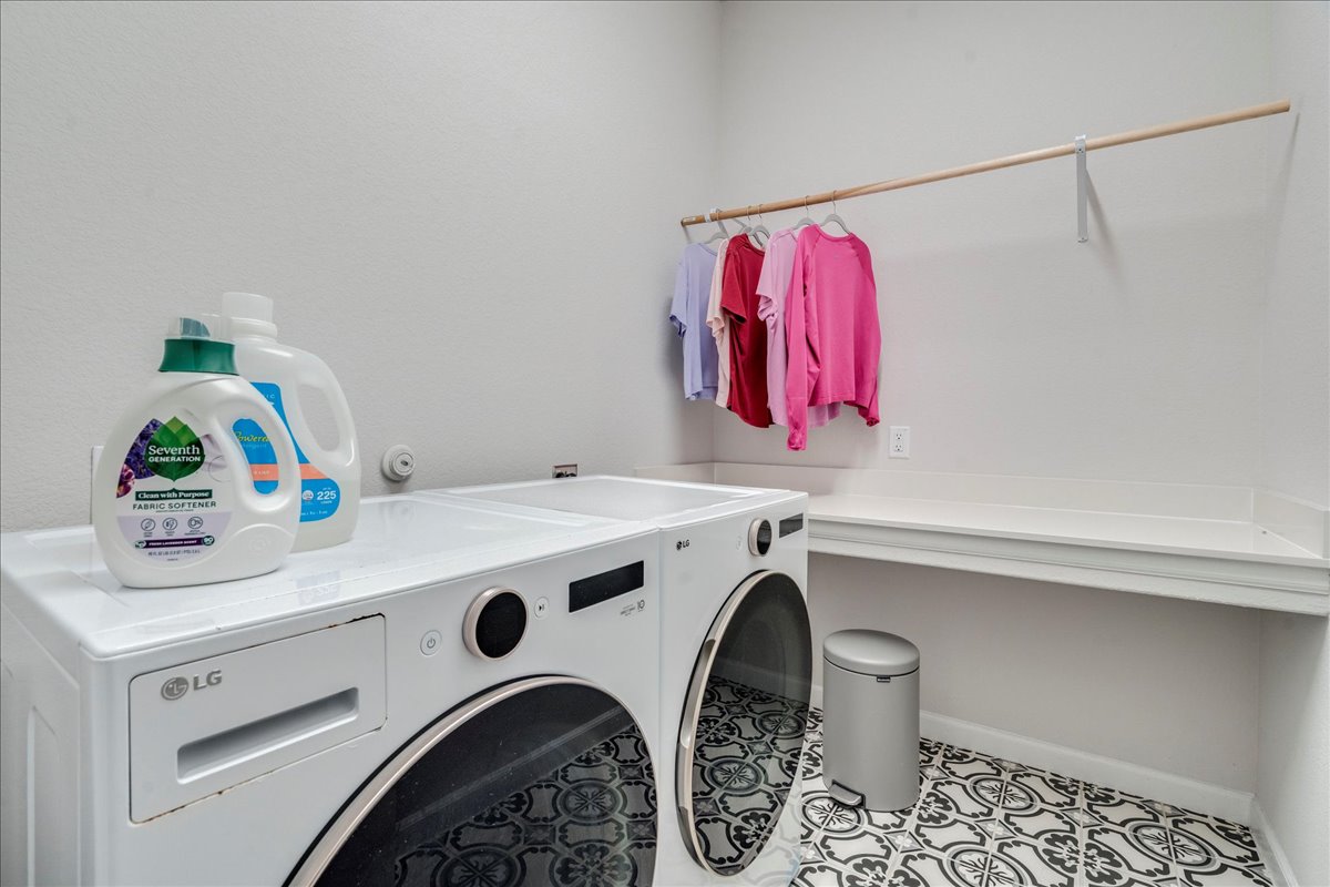 200 Christi Court Kyle, TX 78640 - Photo 30 of 40 Washroom featuring washing machine and clothes dryer and light tile patterned floors
