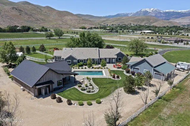 an aerial view of a house with garden space and mountain view in back