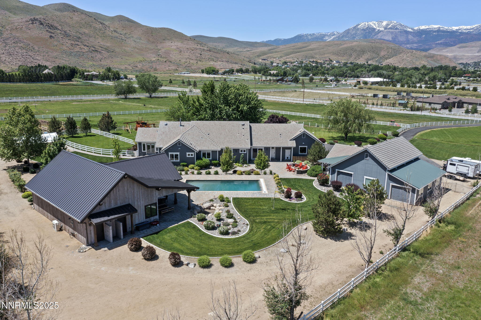 an aerial view of a house with garden space and mountain view in back