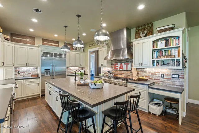 a kitchen with a dining table chairs stainless steel appliances and cabinets