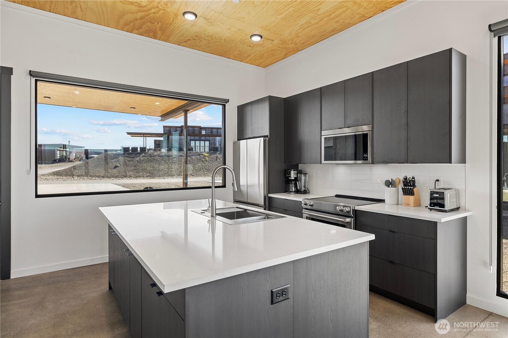 202 Rattlesnake Pt Road Northwest Quincy, WA 98848 - Photo 11 of 37 a kitchen with kitchen island a sink stove and microwave