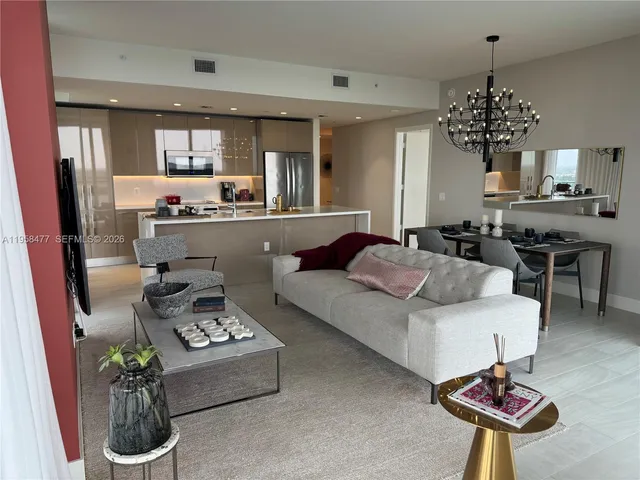 a living room with furniture and a chandelier